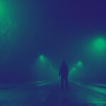 hooded figure standing in the middle of a highway. the image has a black and green filter applied