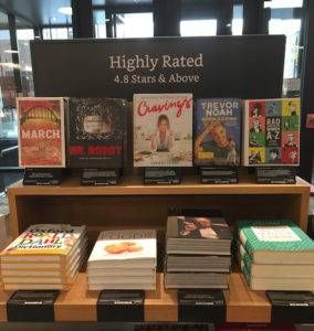 Table displaying multiple books with a sign that says "Highly Rated."