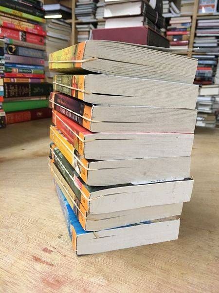 Rubber bands used as bookmarks in a stack of romance pocketbooks.