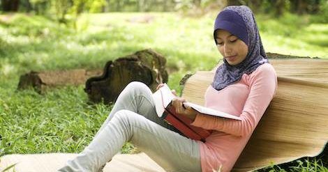 muslim woman in hijab reading a book