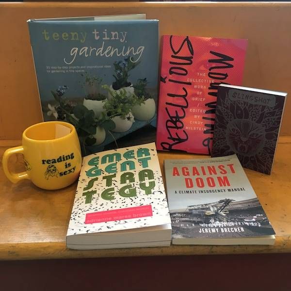 photo of four books, an organizer, and a mug