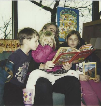 Contributor Emily Polson reads with her mother, sister, and brother at the library, shared in celebration of bookish moms for mother's day