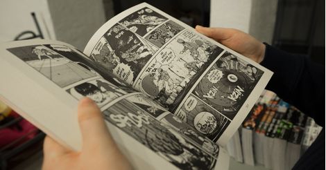 Hands holding an opened comic book
