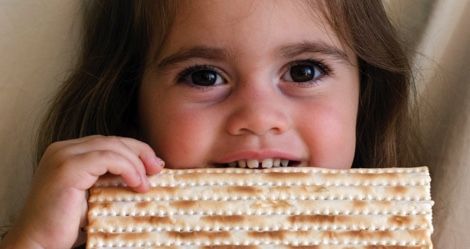 child eating matzah for Passover Judaism feature