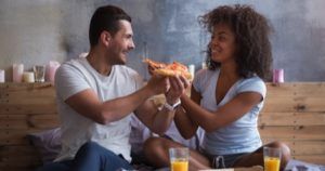 couple feeding each other pizza romance feature