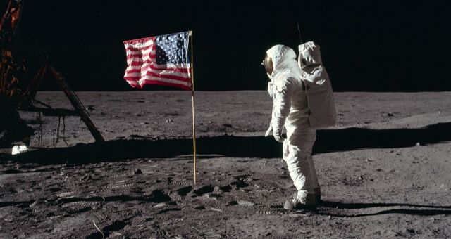 Astronaut Buzz Aldrin, Lunar Module pilot of the first lunar landing mission, poses for a photograph beside the deployed United States flag during an Apollo 11 Extravehicular Activity (EVA) on the lunar surface public domain
