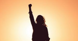 silhouette of a person with one hand raised in a fist