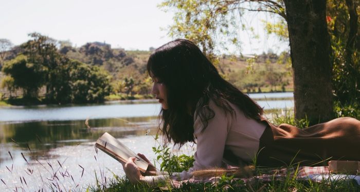 teen reading outdoors for ya books