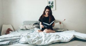a photo of a woman reading in bed