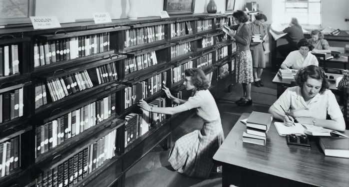 a black and white photo from the 1960s of people in a library