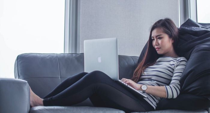 a photo of a woman with a laptop on her lap