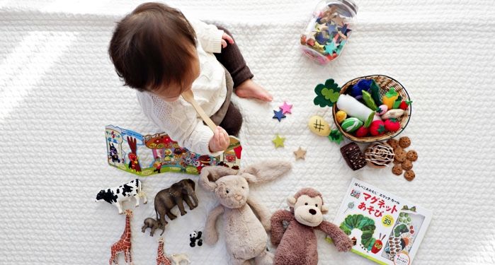 a photo of a baby surrounded by toys and books