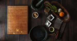 a photo of a cutting board, mortar and pestle, and small dishes of ingredients