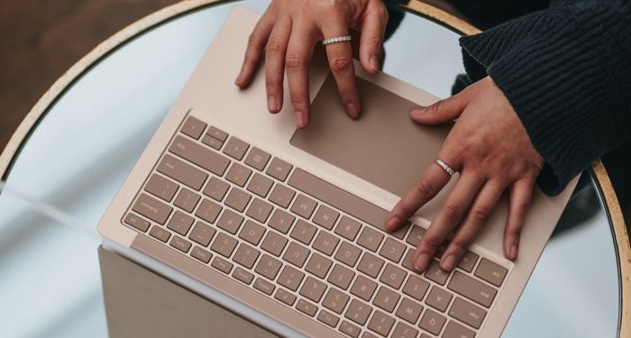a photo of someone typing on a laptop