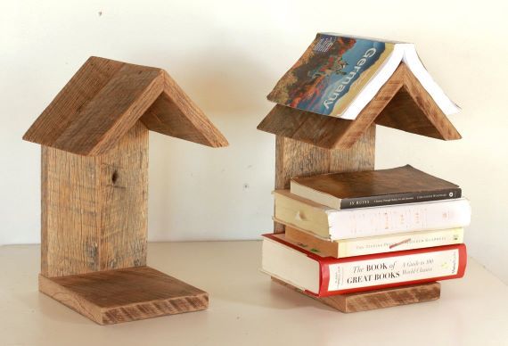 Two wooden portable book stands with trangular shaped tops. The stand on the right holds five books. Link: https://i.etsystatic.com/7540653/r/il/b0bb2e/2115837615/il_1140xN.2115837615_kmli.jpg