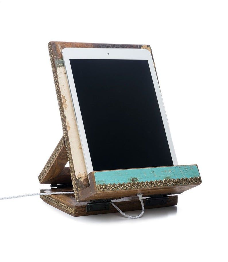 Wooden portable book stand. Oblong shaped. Teal edging. A tablet rests on the stand. Link: https://secure.img1-fg.wfcdn.com/im/01253702/resize-h800-w800%5Ecompr-r85/1156/115681429/Puri+Holder+Accessory.jpg