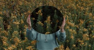 a photo of a woman holding a mirror in a forest