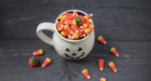 candy corn in a pumpkin mug