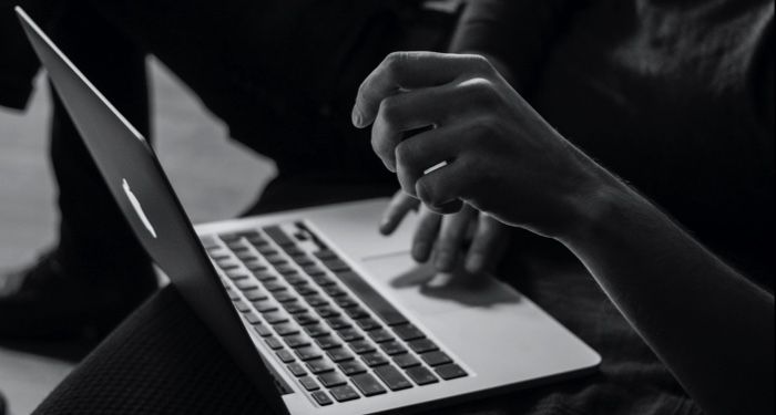 black and white image of hands resting on an open laptop computer https://unsplash.com/photos/_UeY8aTI6d0