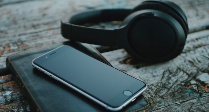 image of a pair of black headphones and a cell phone resting on a journal