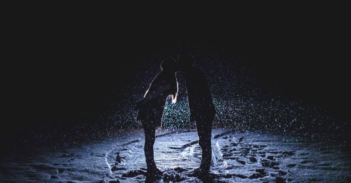 couple kissing on a dark snowy day