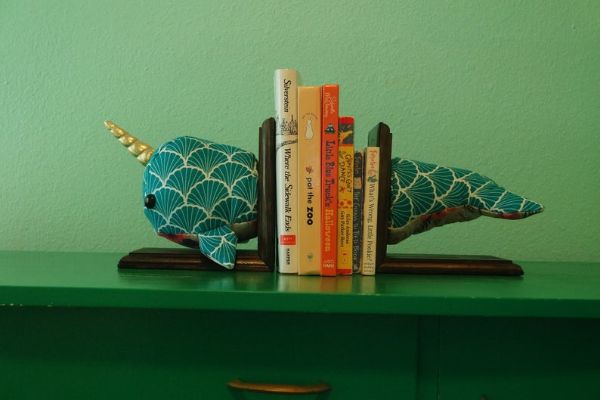 plush narwhal made from geometric fabric, mounted in two pieces on wood bookends