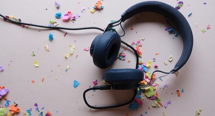 a set of back headphones surrounded by rainbow colored confetti