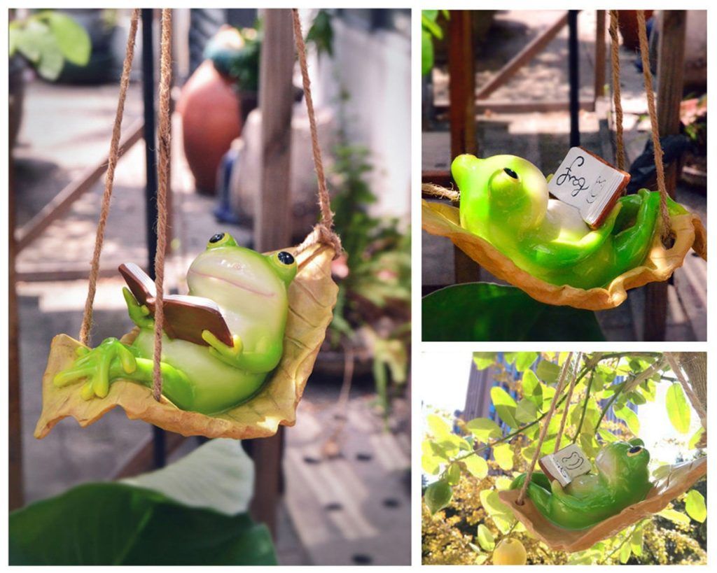 Frog figurine reading in a swing