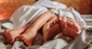 image of two sets of bare legs in bed https://www.pexels.com/photo/couple-love-people-woman-6960001/