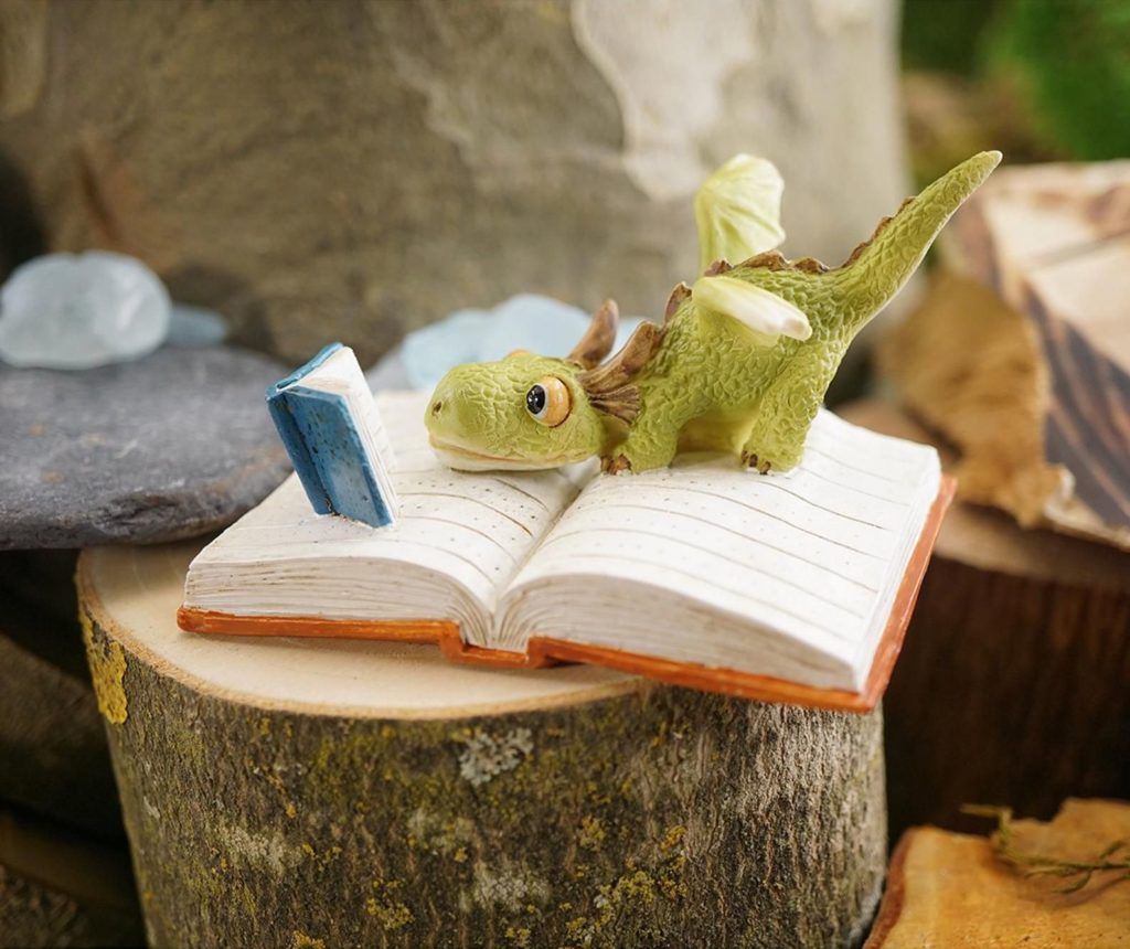 Small resin dragon reading on an open book
