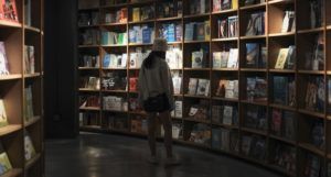 woman browsing in a dark bookstore