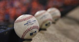 baseballs lined up in a row in a dugout