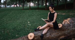 Asian woman reading outdoors