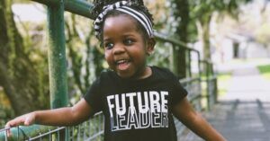 black feminist toddler child wearing a future leader shirt and smiling