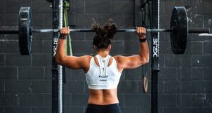 buff woman lifting weights at the gym