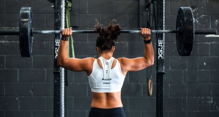 buff woman lifting weights at the gym