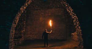 person holding torch in tunnel for horror fantasy feature