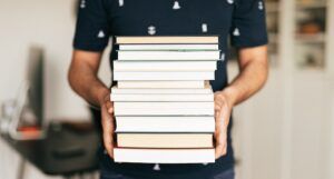a photo of a person holding a stack of books