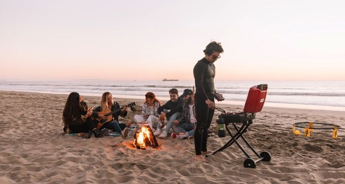 teenagers on the beach with a bonfire and music