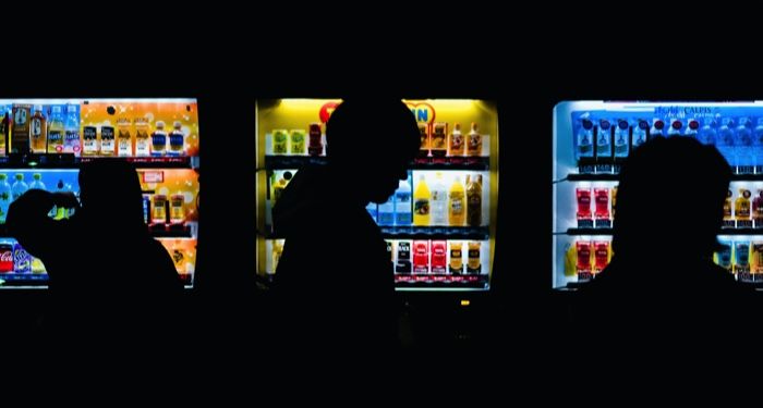vending machines in a dark room with people congregating