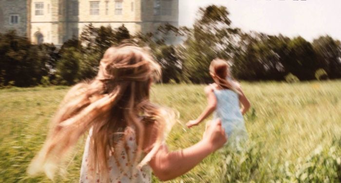 cross section of the cover of I Capture the Castle by Dodie Smith; two girls running through tall grass outside a castle