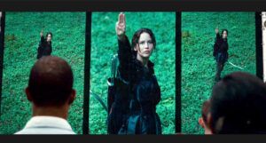 Katniss Everdeen making the three-finger salute in The Hunger Games film