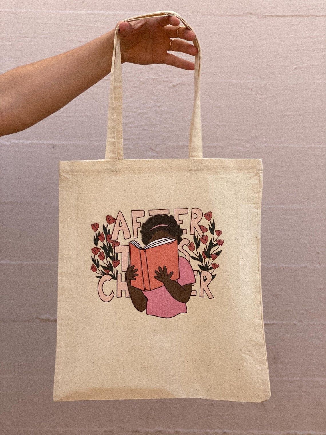 a tote bag with a person holding a book reading in front of the words after this chapter 