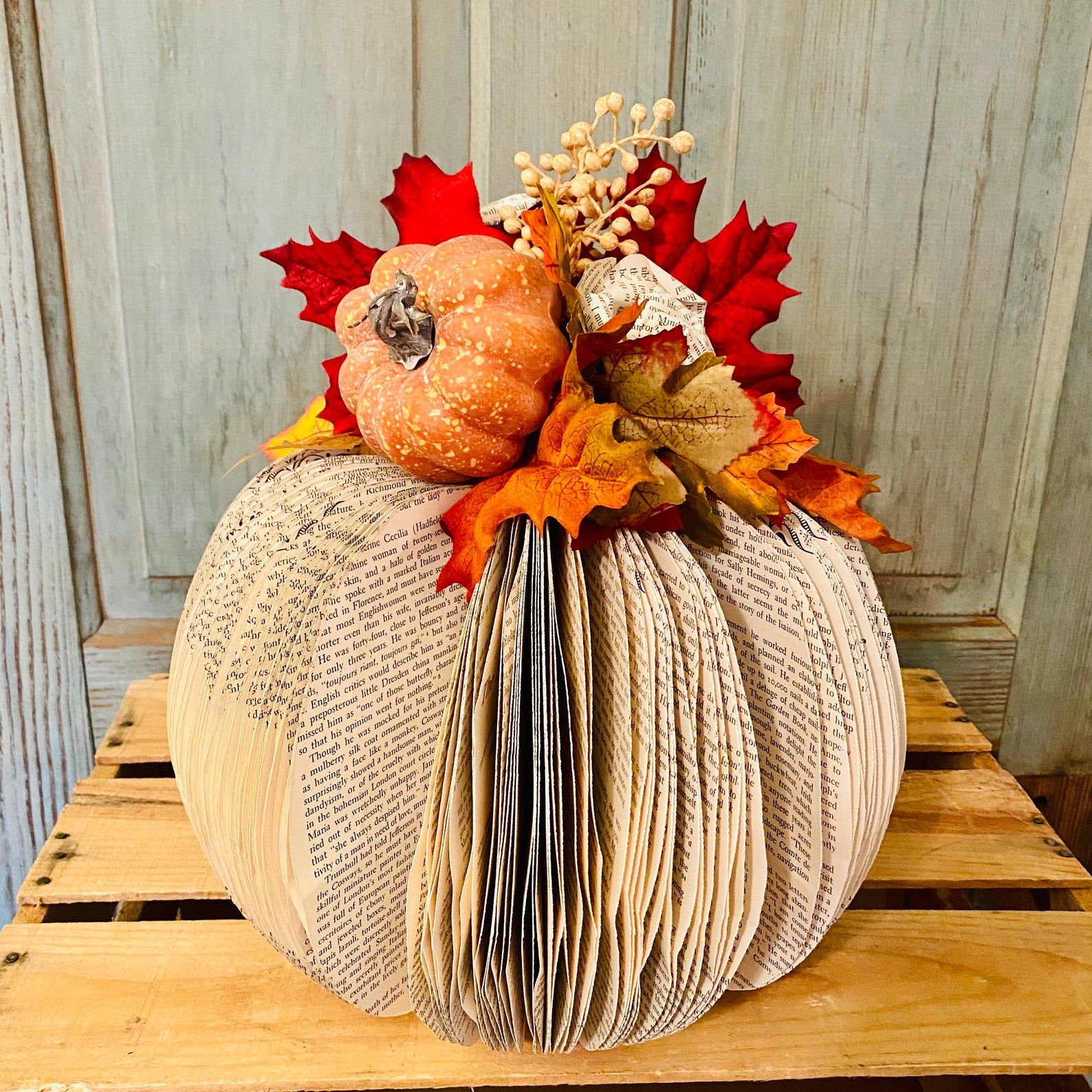 Image of a pumpkin made of book pages. 