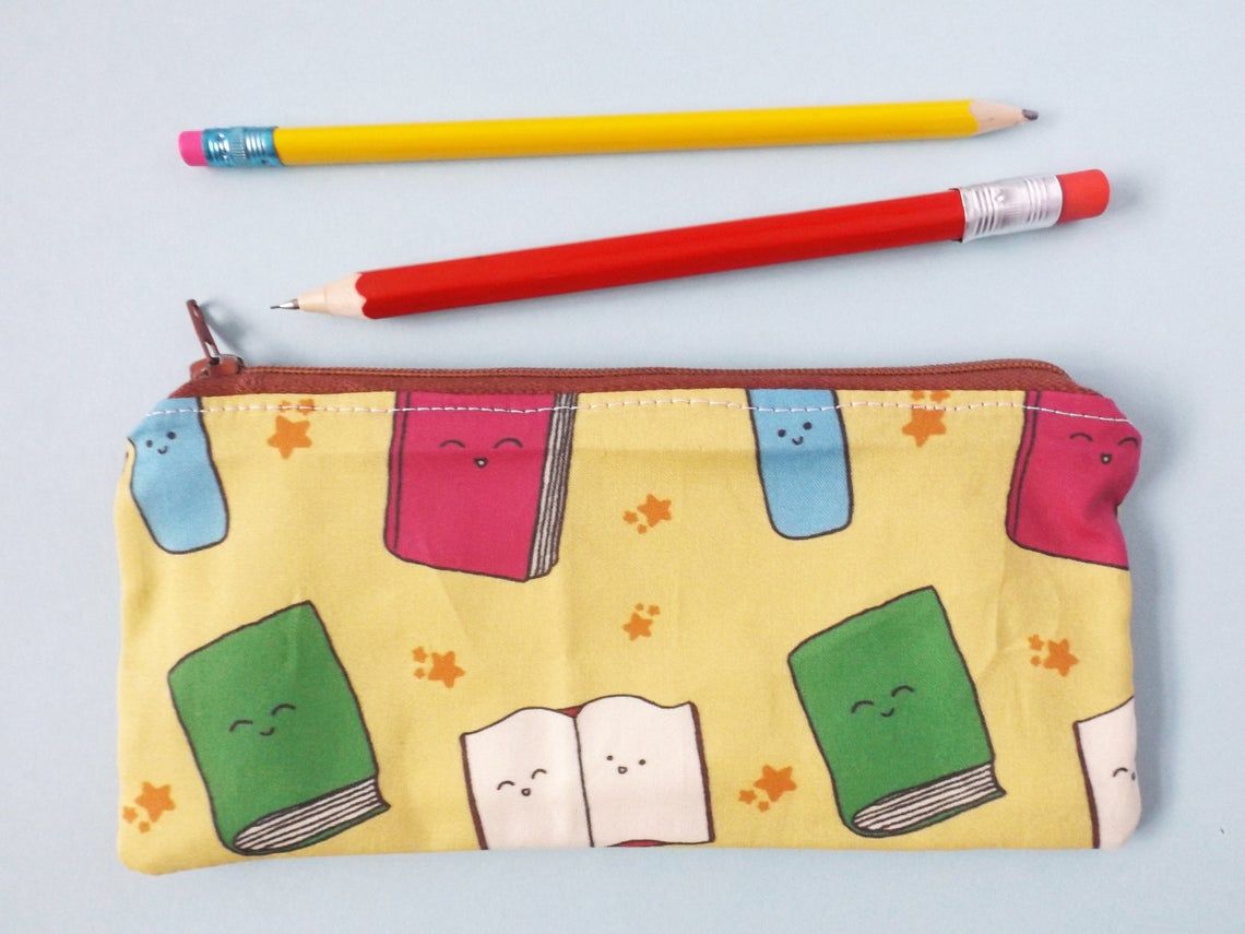zipper pencil case featuring cartoon books with happy faces 