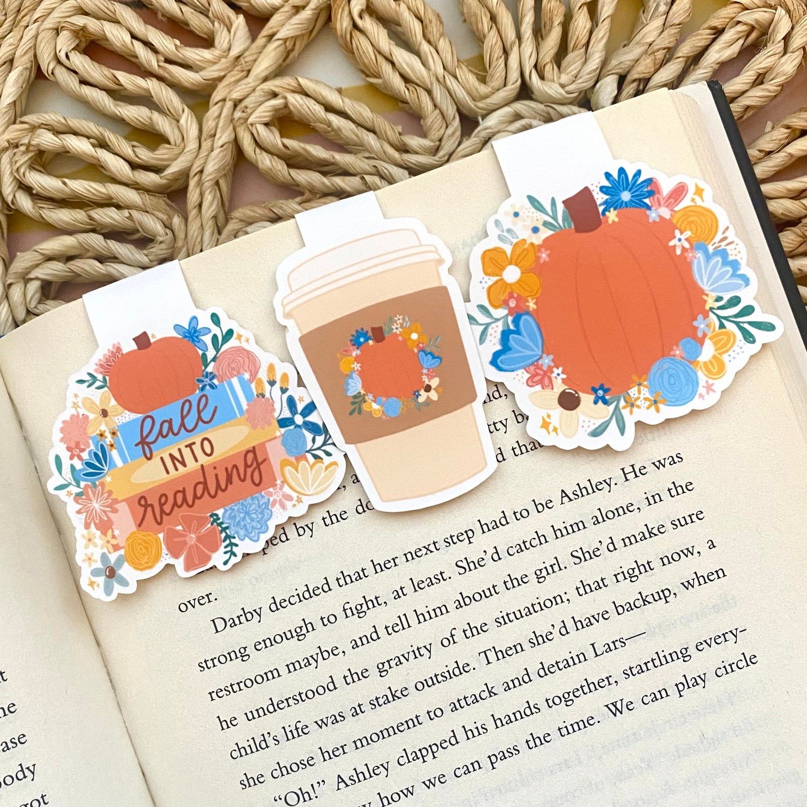 Image of three fall-themed magnetic bookmarks at the top of an open book page. 