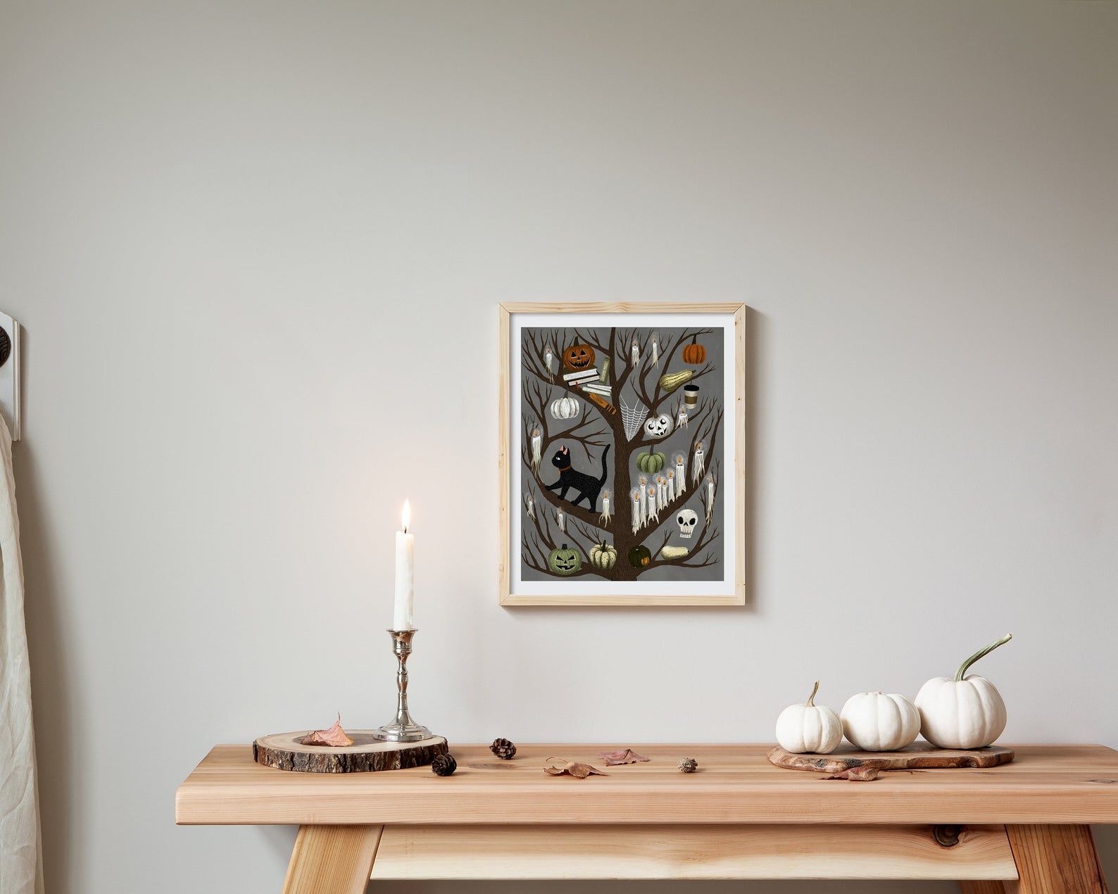 Image of spooky tree art, with branches featuring books, skeletons, ghosts, cats, and pumpkins.