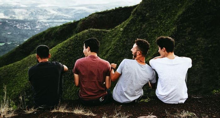 a row of four men sitting on a mountain trail https://unsplash.com/photos/TkrRvwxjb_8