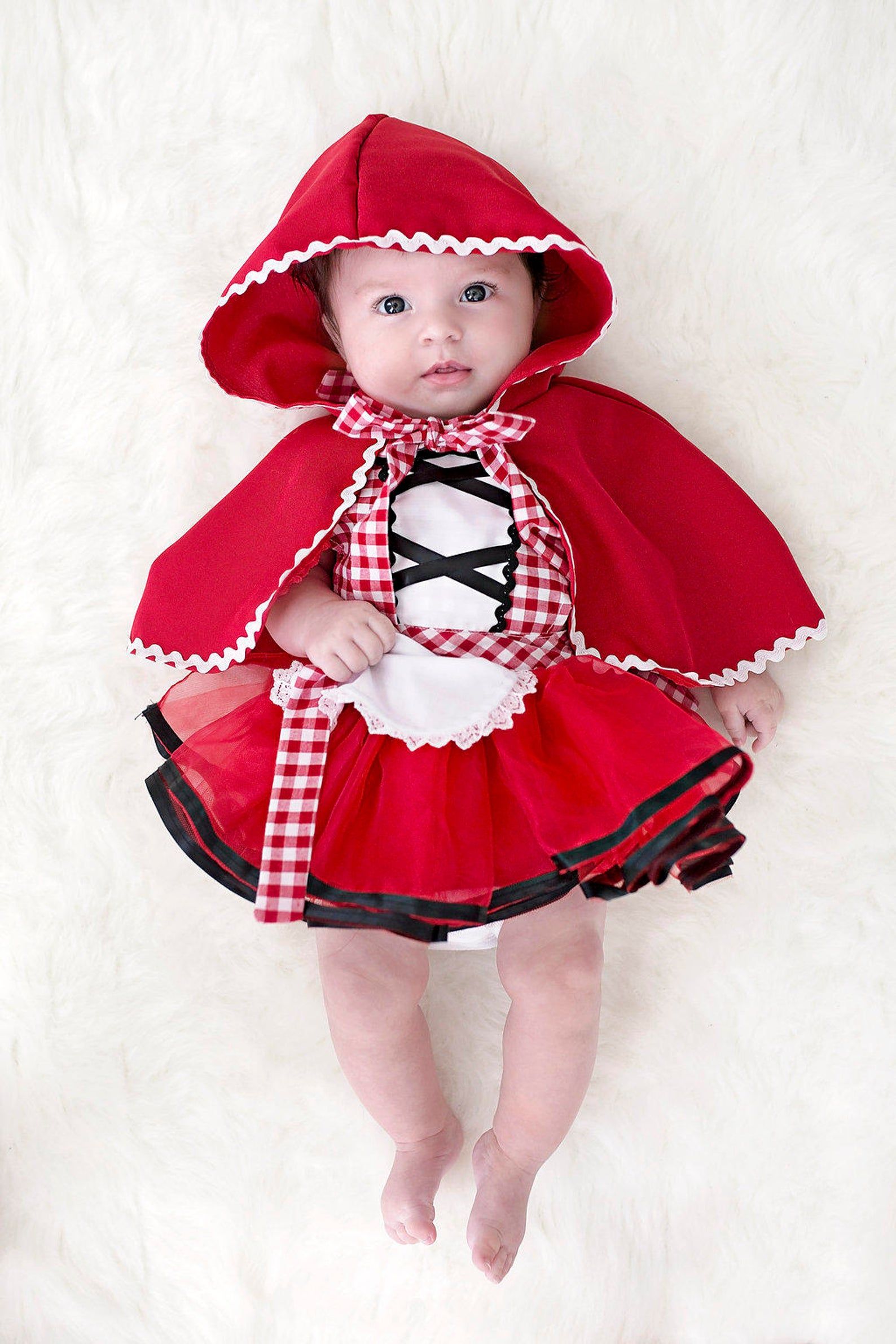 Image of a baby in a Little Red Riding Hood costume. 