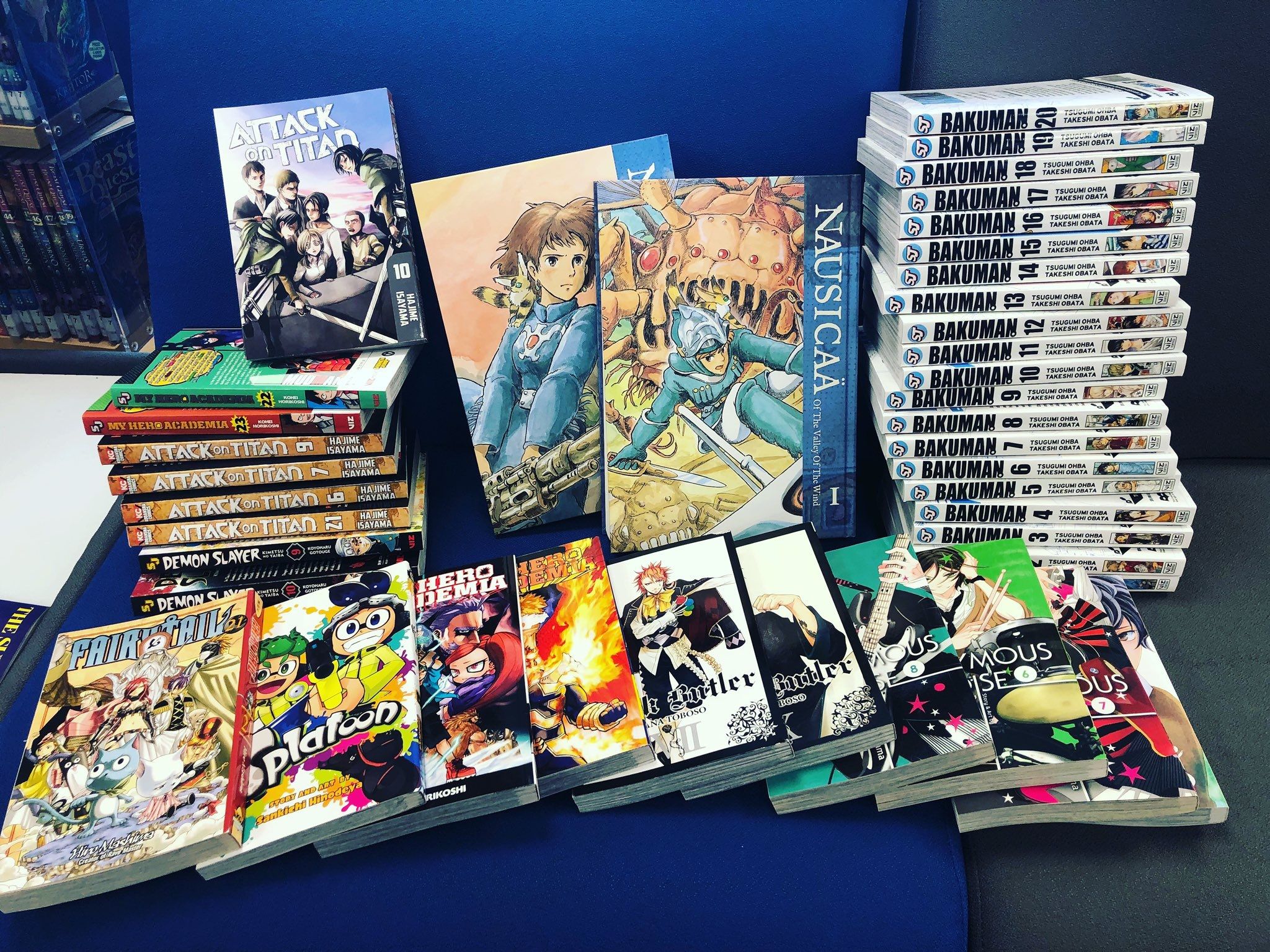 An assortment of manga on a library seat including Bakuman, Splatoon and more. 